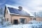 The image shows a snow-covered detached house with a PV system on the roof and a heat pump in the garden.